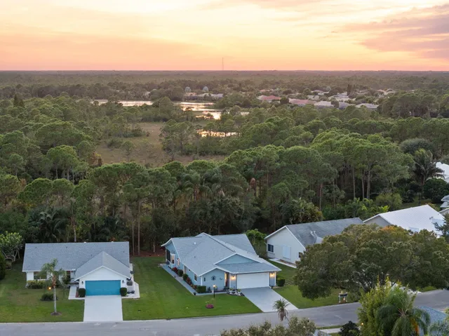 an aerial view of residential houses with outdoor space and trees