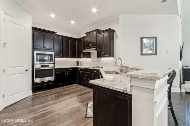 a kitchen with stainless steel appliances granite countertop a sink stove and refrigerator