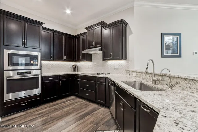 a kitchen with a refrigerator and a stove top oven