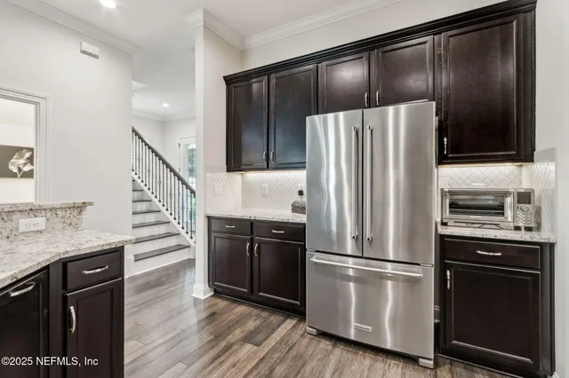a bed sitting in a bedroom next to a window and a chandelier