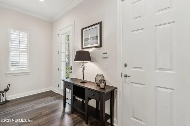 a living room with fireplace furniture wooden floor and a large window