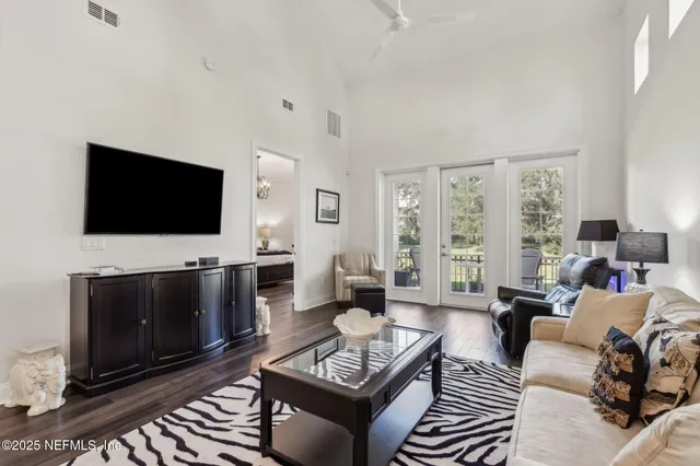 a living room with furniture a flat screen tv and kitchen view