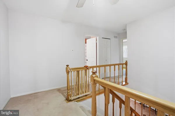 a view of staircase with railing and white walls