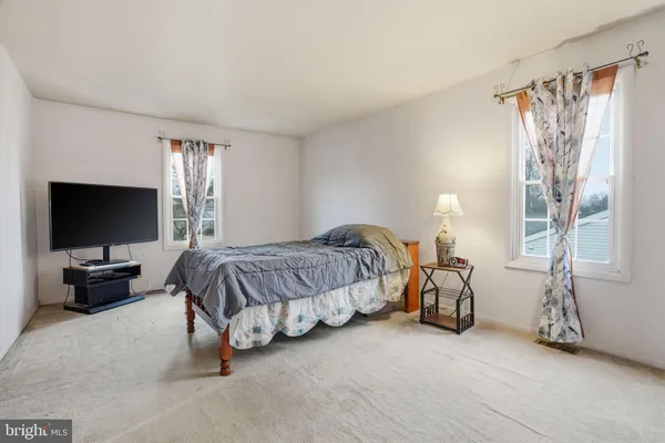 a spacious bedroom with a bed and a flat screen tv