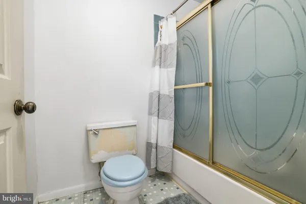 a bathroom with a granite countertop toilet and a shower
