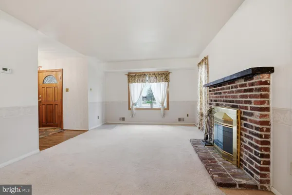 a view of an empty room with window and fireplace