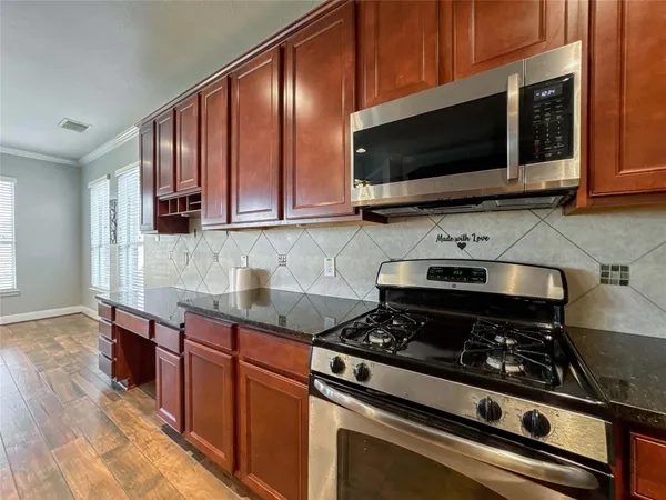 a kitchen with stainless steel appliances a sink stove and microwave