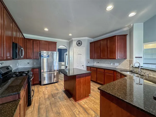 a kitchen with stainless steel appliances granite countertop a sink stove and refrigerator