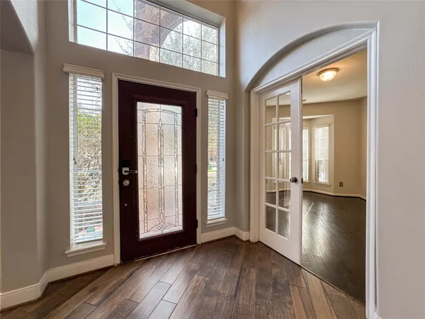 an empty room with wooden floor and windows