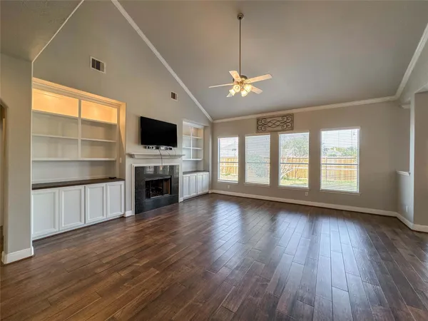 a view of a livingroom with a fireplace wooden floor and window