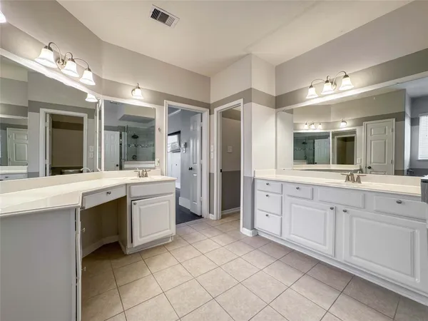 a large bathroom with a large mirror vanity and a sink