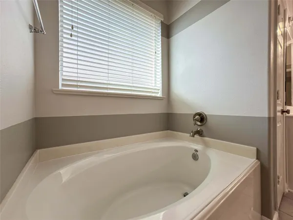 a white bath tub sitting in a bathroom next to a window