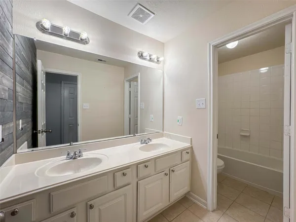 a bathroom with double sink and a mirror