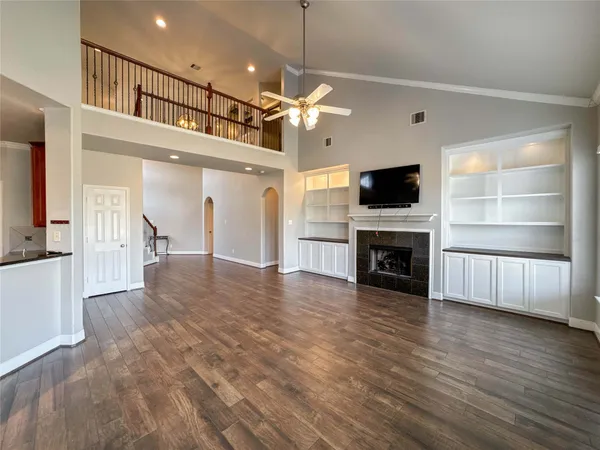 a view of a livingroom with a ceiling fan wooden floor and a fireplace