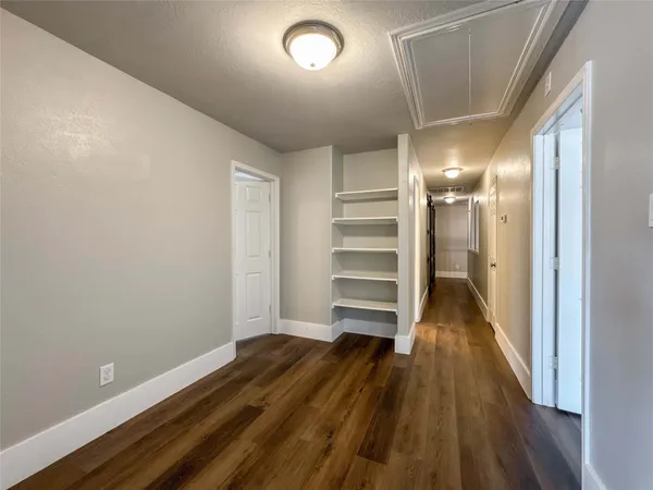 a view of empty room with wooden floor