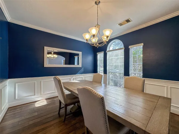 a view of a dining room with furniture a chandelier and wooden floor