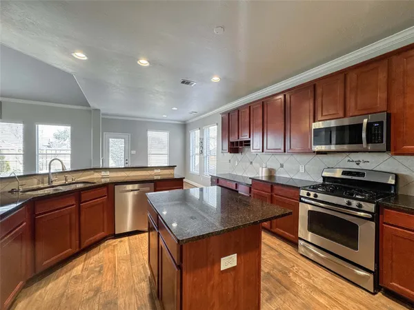 a kitchen with stainless steel appliances granite countertop a stove microwave sink and refrigerator