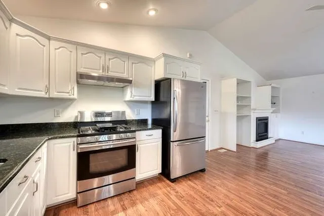 a kitchen with stainless steel appliances granite countertop a stove a refrigerator and a microwave