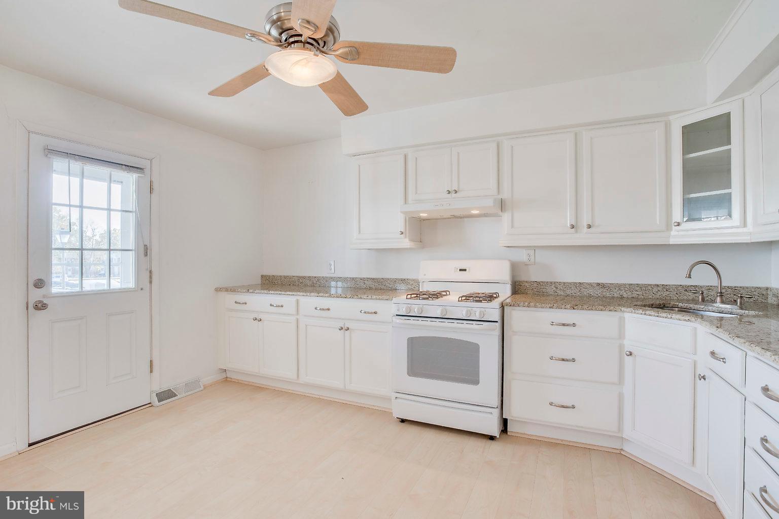 2011 Shore Road Dundalk, MD 21222 - Photo 25 of 37 a kitchen with granite countertop white cabinets white stainless steel appliances a sink and a window