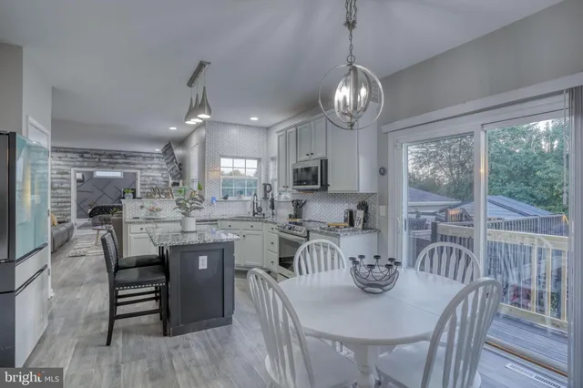 a room with furniture pool table and kitchen view