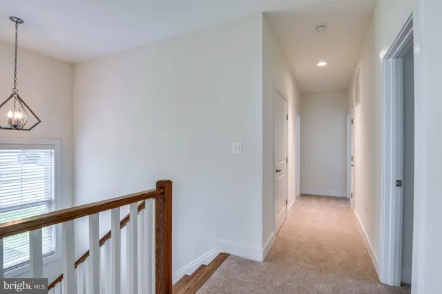 a view of a hallway to rooms and stairs