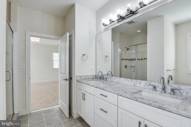 a bathroom with a granite countertop sink a mirror and a shower