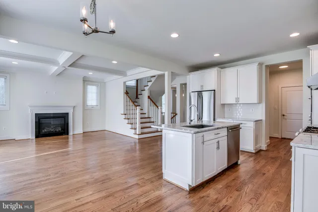 a kitchen with stainless steel appliances granite countertop a stove top oven a sink and a refrigerator