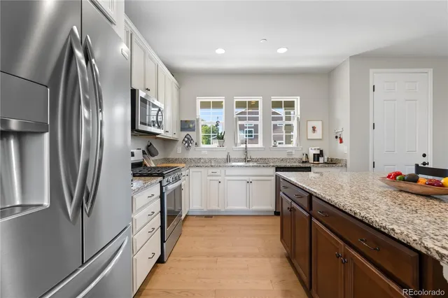 a kitchen with stainless steel appliances granite countertop a sink stove and refrigerator