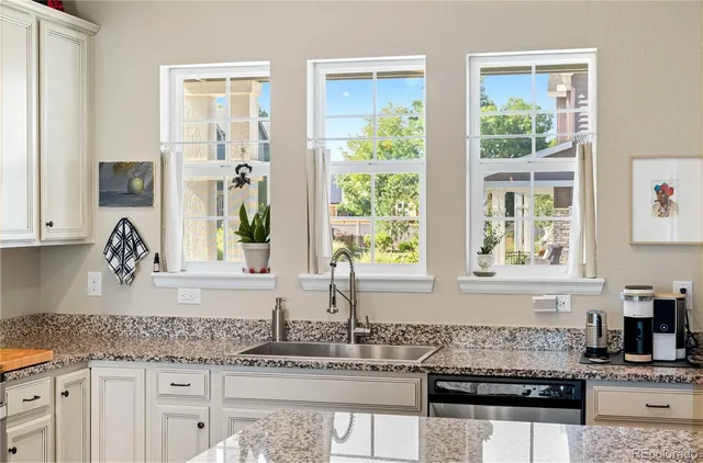 a kitchen with granite countertop a stove a sink and a counter space