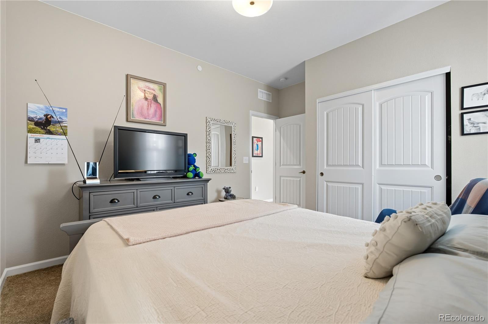 10074 Flower Street Broomfield, CO 80021 - Photo 28 of 47 a bedroom with a bed and a flat screen tv