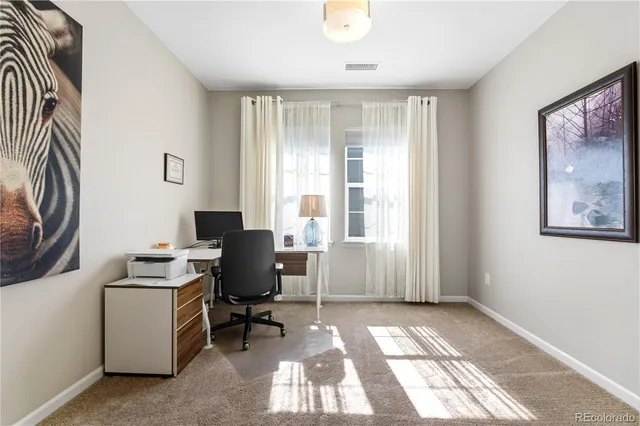 a view of a workspace with furniture and a window