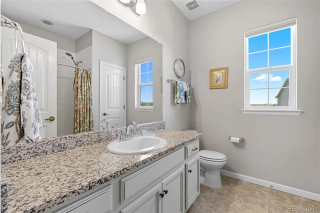 a bathroom with a granite countertop sink toilet and shower