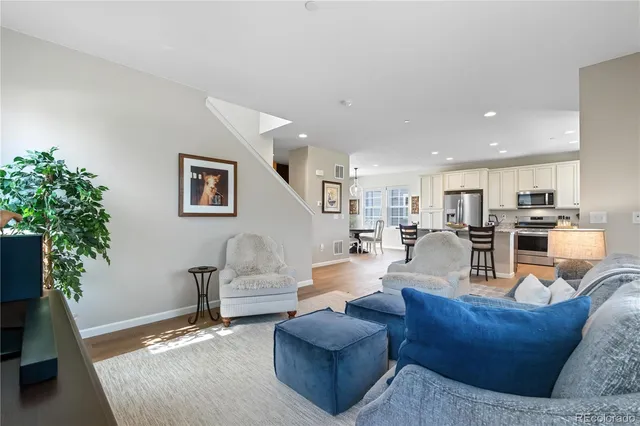 a living room with furniture kitchen view and a potted plant