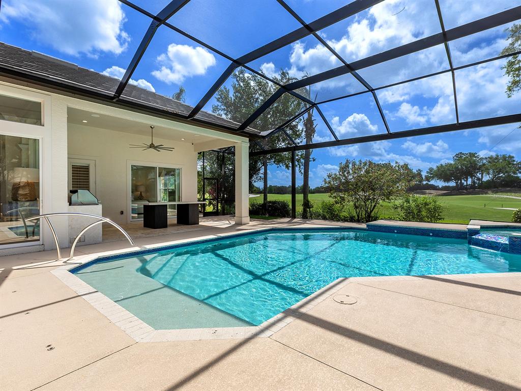 7431 Greystone Street Lakewood Ranch, FL 34202 - Photo 60 of 85 a view of a patio with a table and chairs under an umbrella