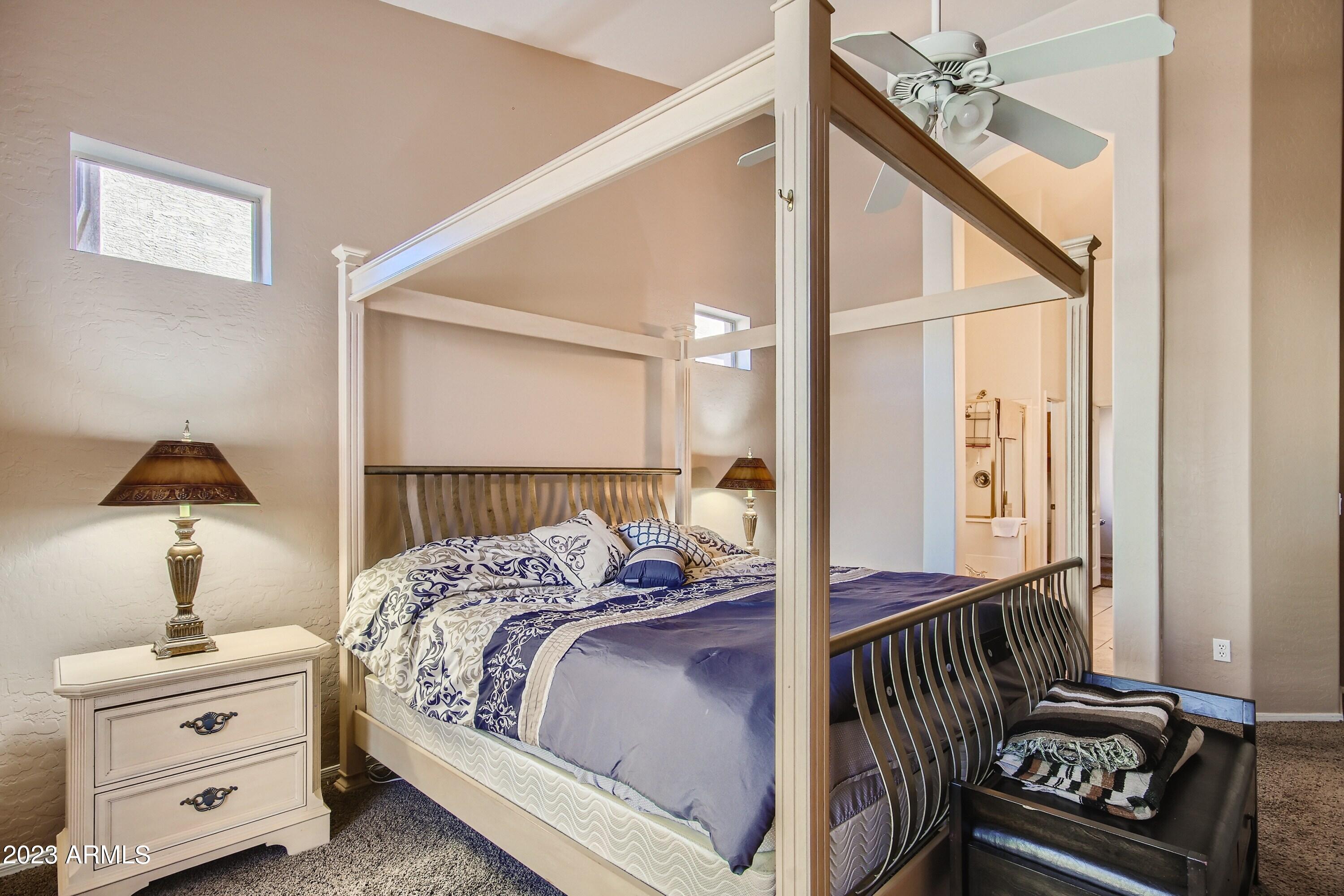 3060 North Ridgecrest, Unit 175 Mesa, AZ 85207 - Photo 17 of 28 a bedroom with a bed and a chandelier