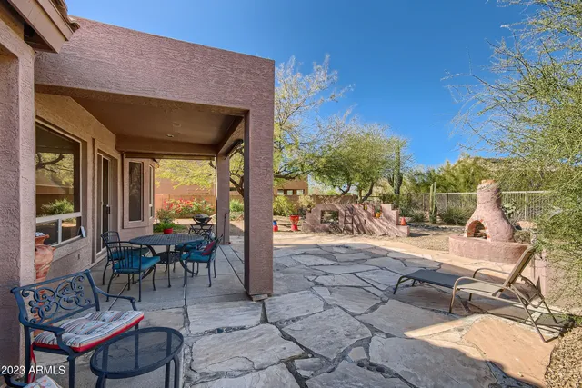 a view of a patio with a table and chairs under an umbrella
