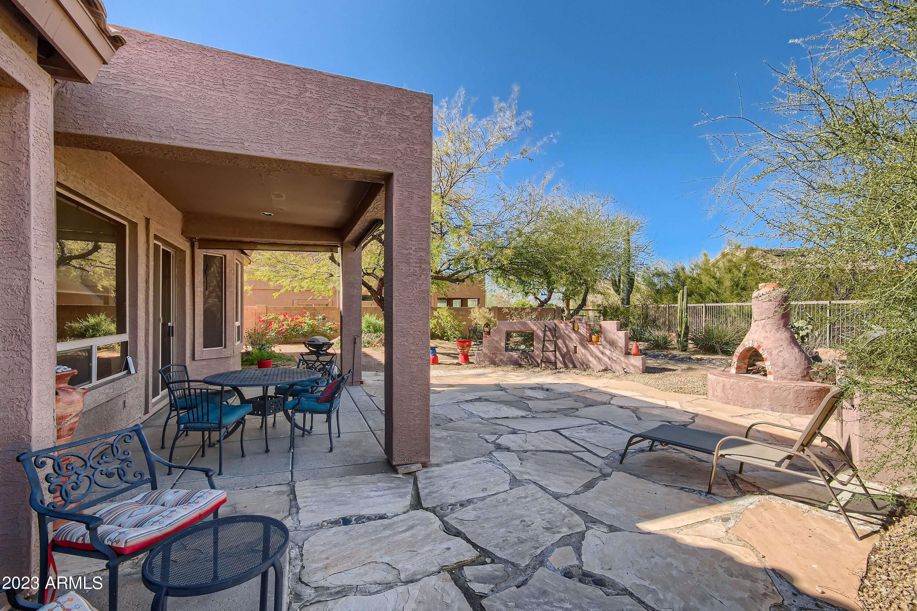 3060 North Ridgecrest, Unit 175 Mesa, AZ 85207 - Photo 25 of 28 a view of a patio with table and chairs potted plants and a large tree