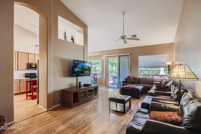 a living room with furniture a flat screen tv and a large window