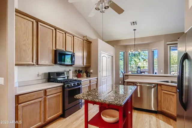 a kitchen with stainless steel appliances granite countertop a sink stove microwave and wooden floor