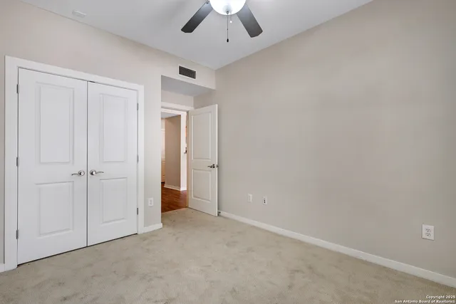an empty room with a ceiling fan and a window