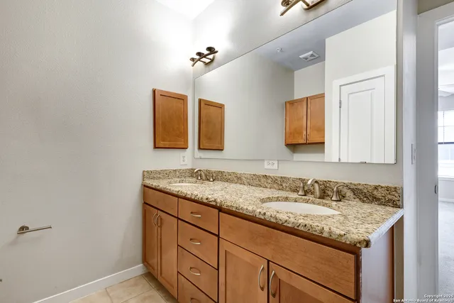 a bathroom with a granite countertop sink and a mirror