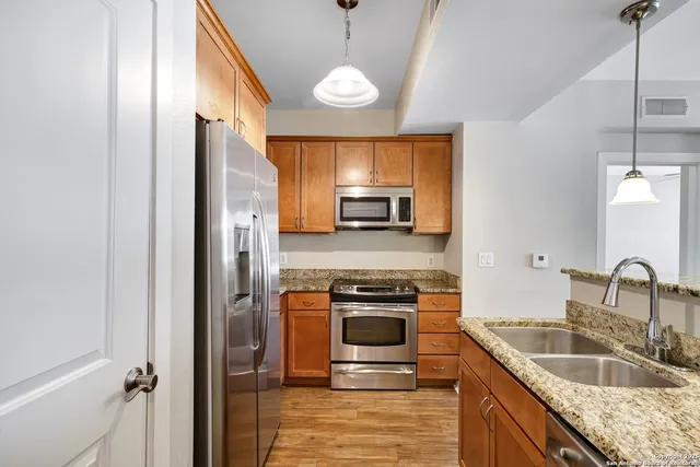 a kitchen with stainless steel appliances granite countertop a sink stove and refrigerator