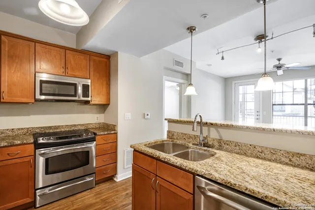 a kitchen with granite countertop a sink and steel appliances
