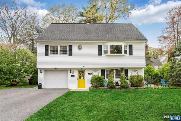 a front view of a house with a garden and yard