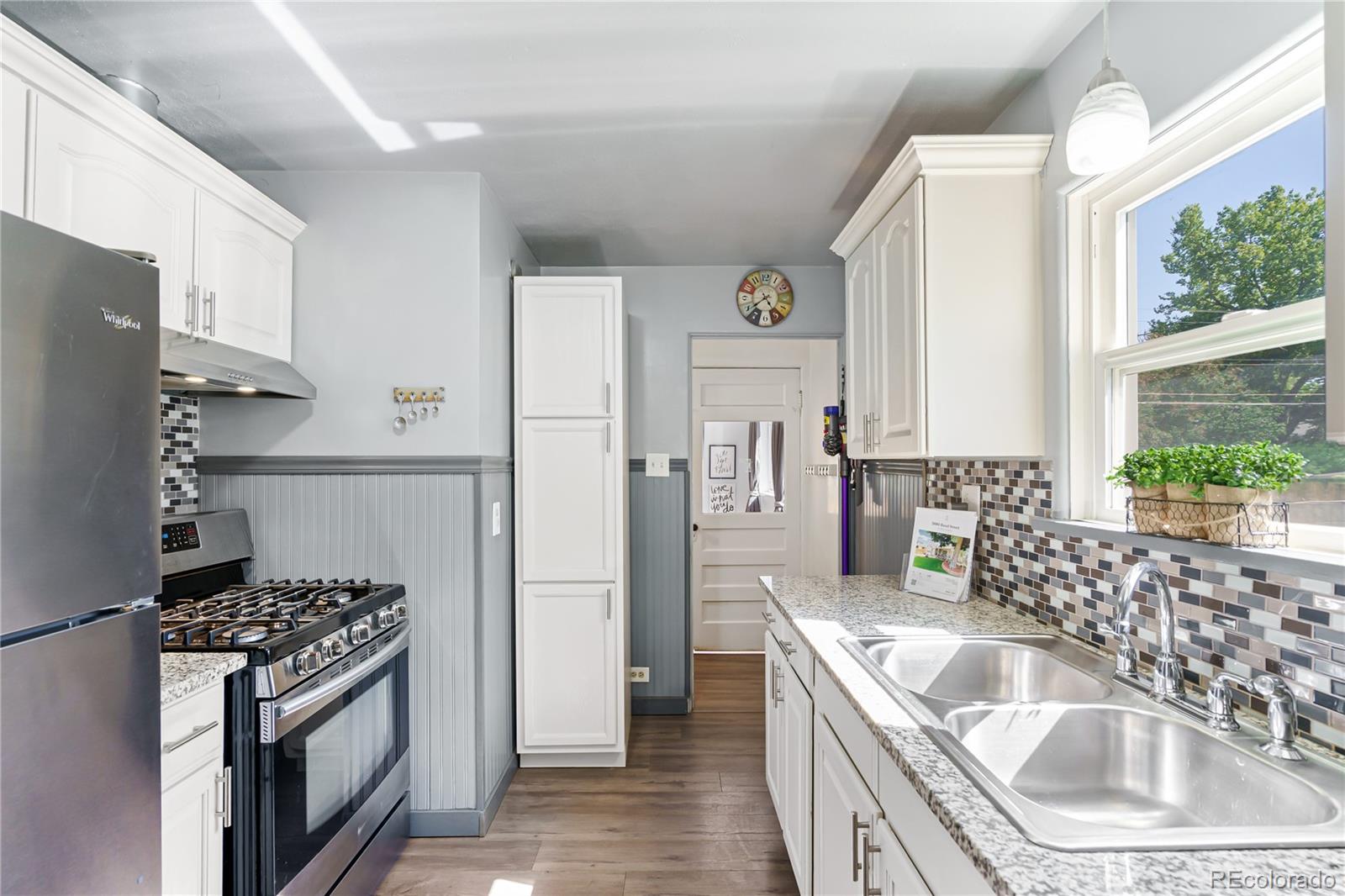 3880 Reed Street Wheat Ridge, CO 80033 - Photo 13 of 40 a kitchen with stainless steel appliances granite countertop a sink stove and refrigerator