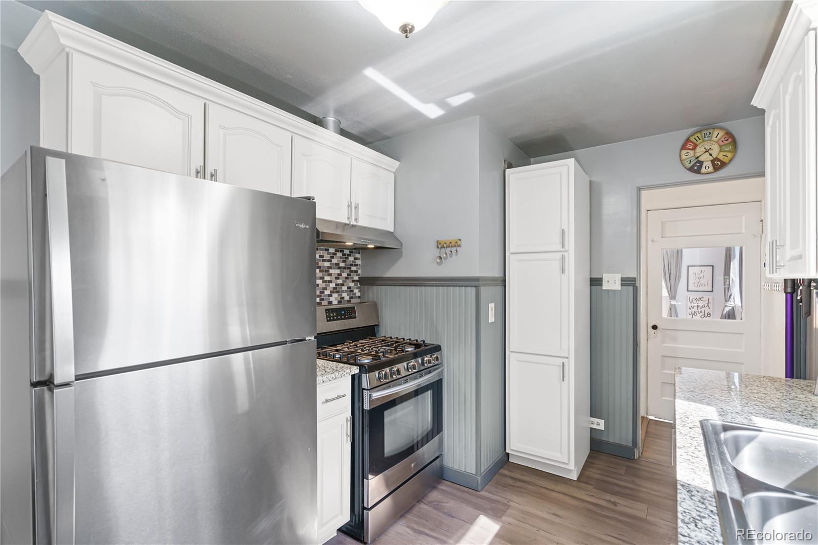 3880 Reed Street Wheat Ridge, CO 80033 - Photo 15 of 40 a white refrigerator freezer and a stove sitting inside of a kitchen