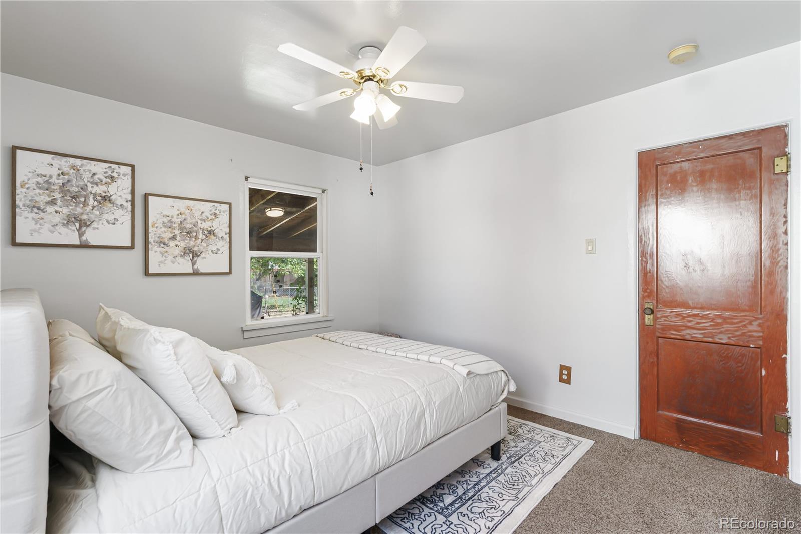 3880 Reed Street Wheat Ridge, CO 80033 - Photo 20 of 40 a bedroom with a large bed and a chandelier