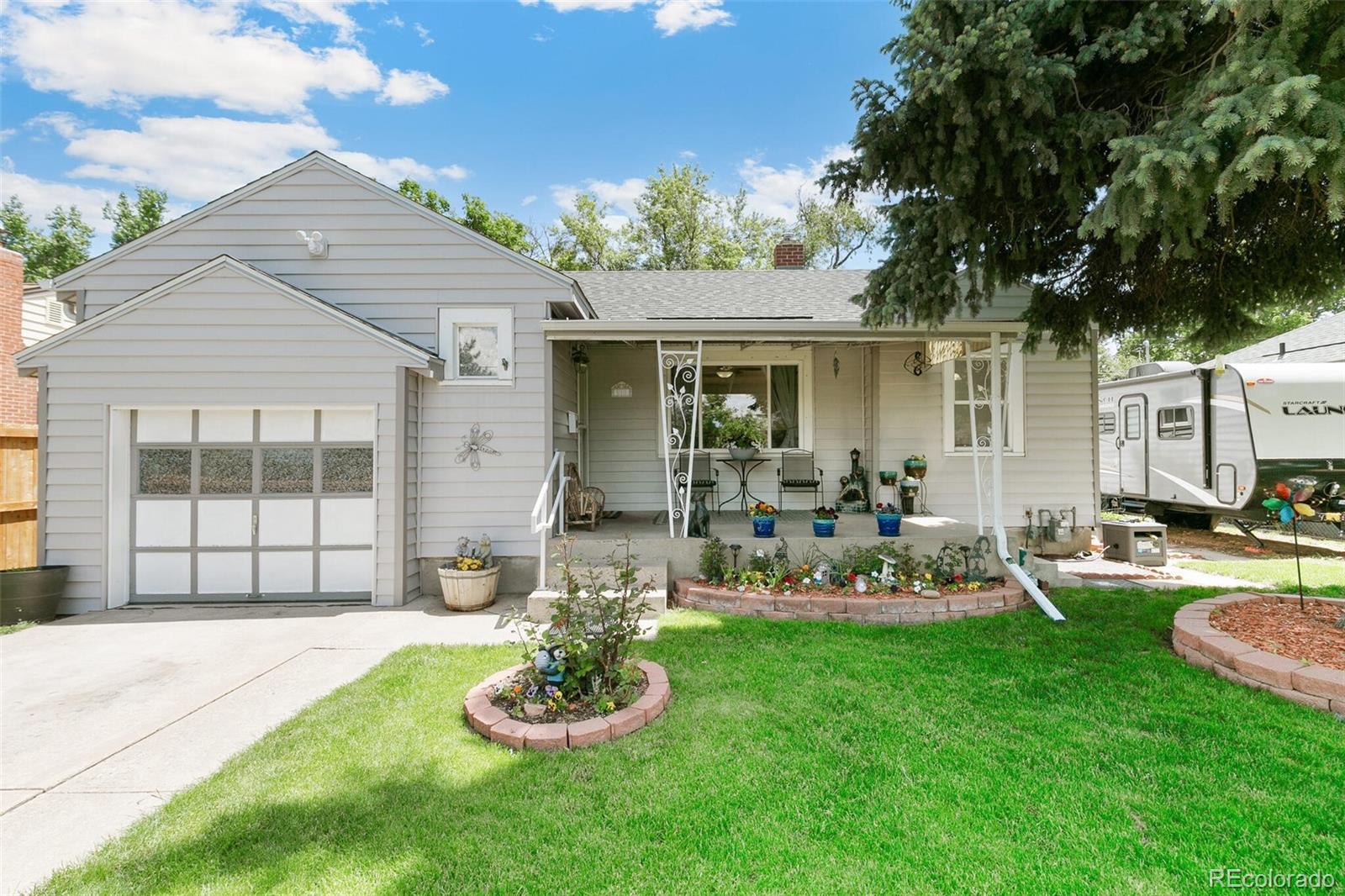 3880 Reed Street Wheat Ridge, CO 80033 - Photo 2 of 40 a front view of a house with a garden and patio