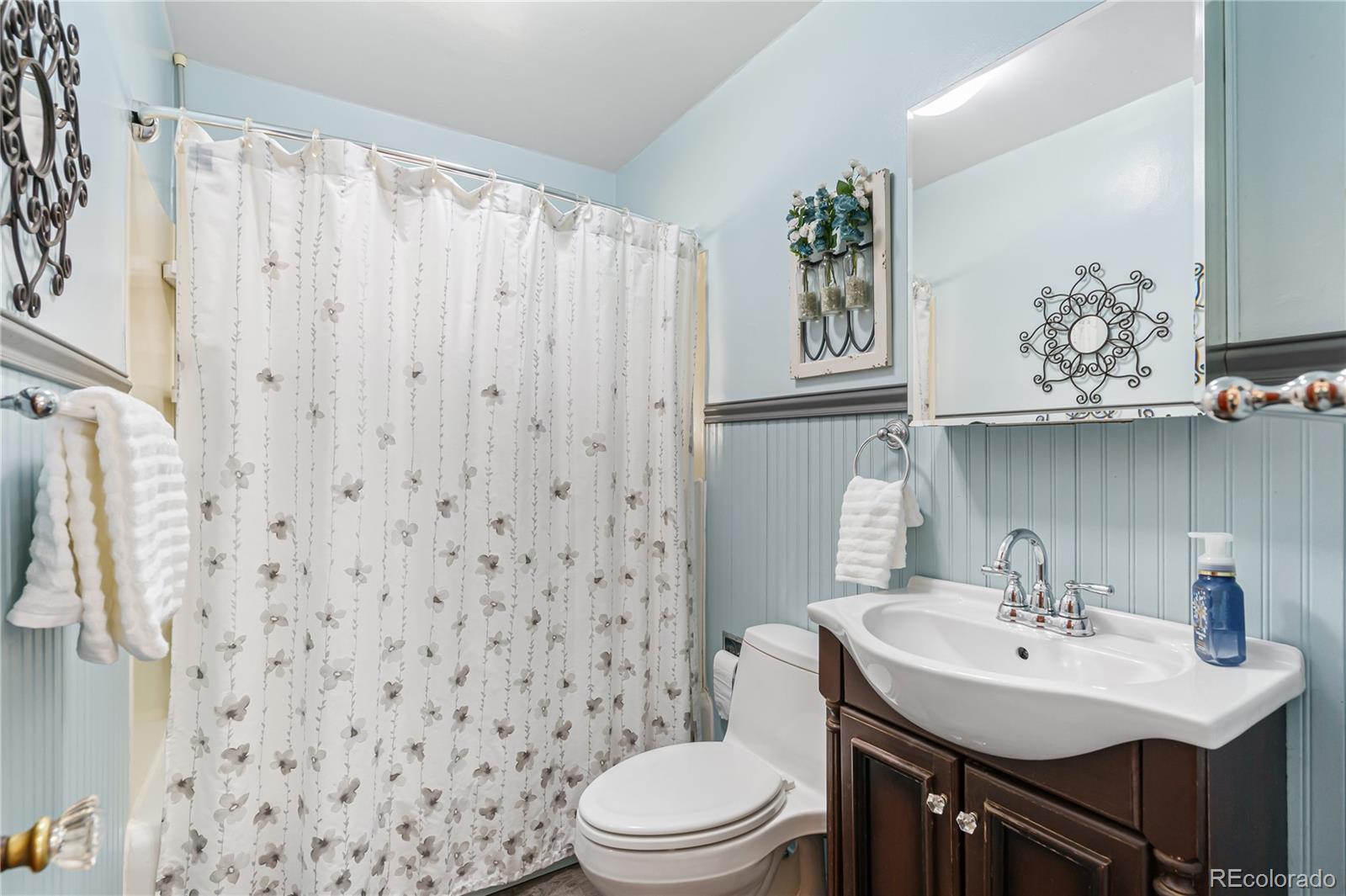 3880 Reed Street Wheat Ridge, CO 80033 - Photo 21 of 40 a bathroom with a sink a toilet and a mirror