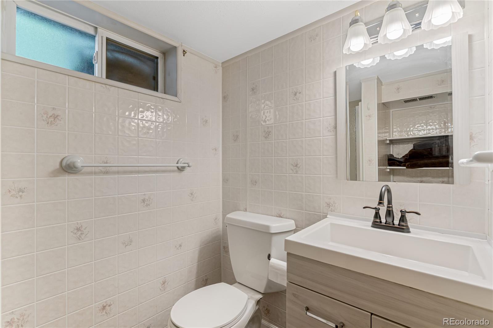 3880 Reed Street Wheat Ridge, CO 80033 - Photo 29 of 40 a bathroom with a sink a toilet and shower